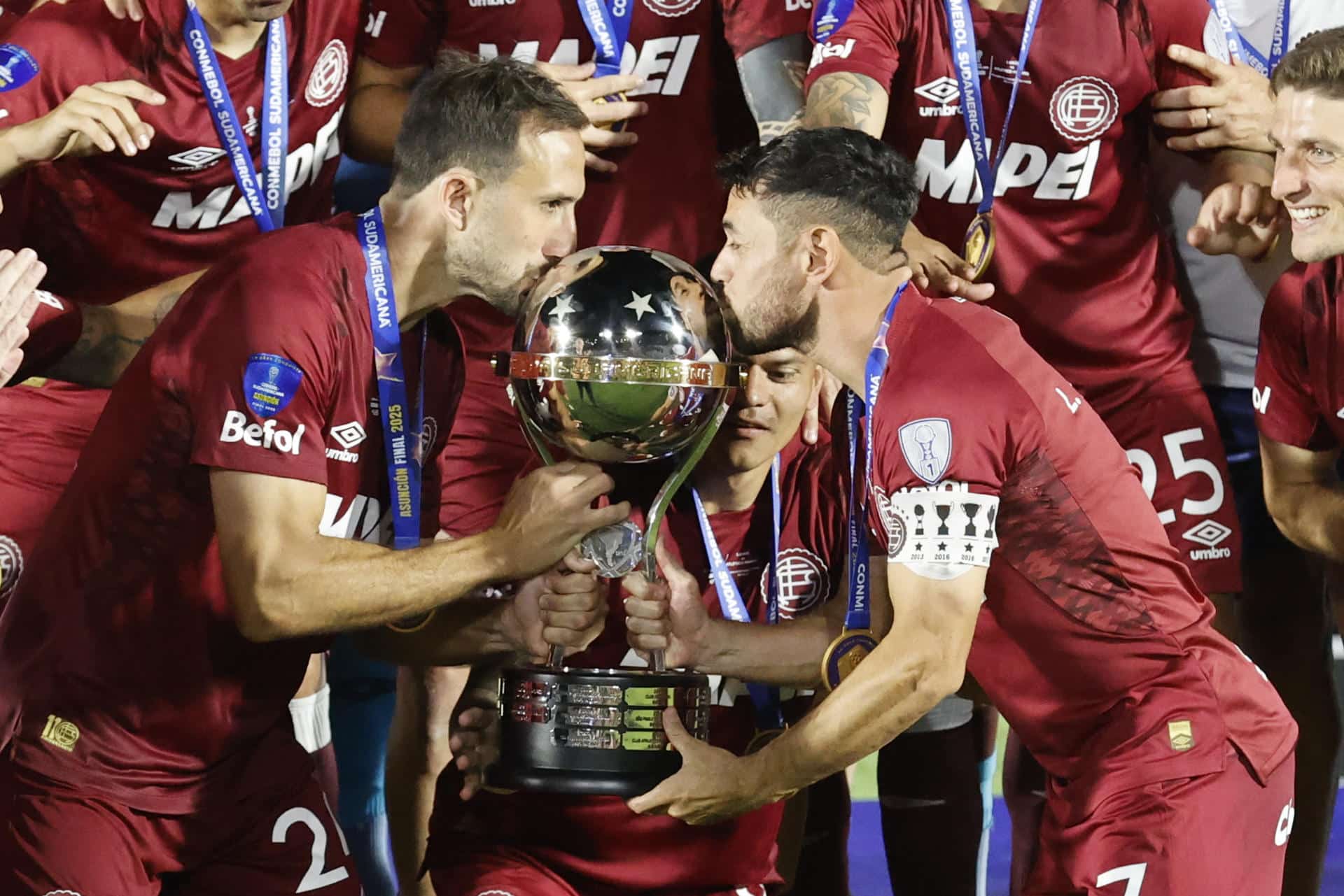 Carlos Izquierdoz (i) y Lautaro Acosta, de Lanús, celebran con el trofeo al ganar la Copa Sudamericana ante Atlético Mineiro en el estadio Defensores del Chaco en Asunción (Paraguay). EFE/Mauricio Dueñas Castañeda