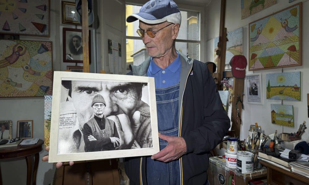 El pintor Silvio Parrello 'er Pecetto' posa con un retrato de Pasolini en su estudio de Roma . EFE/ Daniel Cáceres