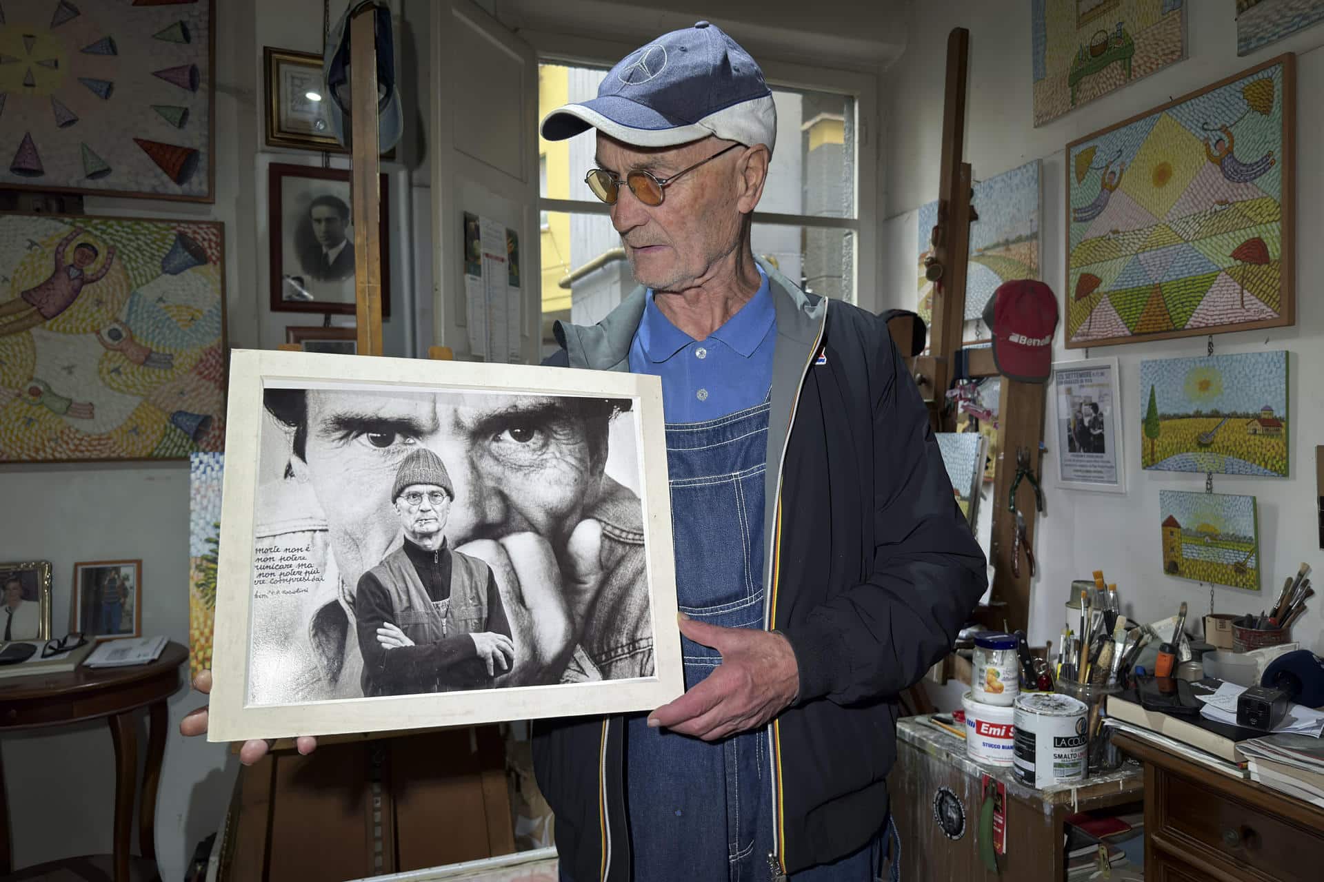 El pintor Silvio Parrello 'er Pecetto' posa con un retrato de Pasolini en su estudio de Roma . EFE/ Daniel Cáceres