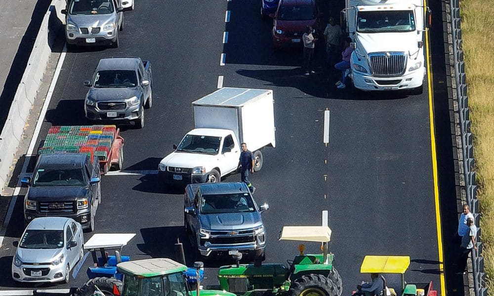 Fotografía aérea que muestra vehículos de carga estacionados durante un bloqueo de agricultores en la carretera que comunica de León a Aguascalientes este martes, en León (México). Agricultores del estado de Guanajuato (centro del país) bloquearon diversas carreteras tras no llegar a un acuerdo con el gobierno federal para establecer un precio mínimo a la tonelada de maíz y el sorgo. EFE/ Luis Ramírez