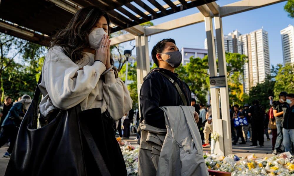 Personas rezan por las víctimas del incendio en el complejo residencial Wang Fuk Court en el distrito de Tai Po en Hong Kong, China, 29 de noviembre de 2025. Las autoridades informaron este sábado de que 144 personas inicialmente dadas por desaparecidas han sido localizadas ilesas, mientras que alrededor de 150 continúan sin poder ser contactadas. EFE/EPA/LEUNG MAN HEI