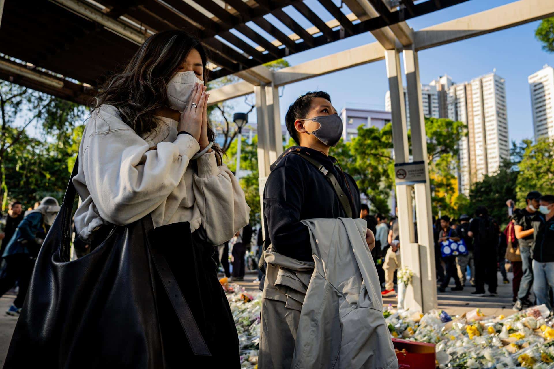 Personas rezan por las víctimas del incendio en el complejo residencial Wang Fuk Court en el distrito de Tai Po en Hong Kong, China, 29 de noviembre de 2025. Las autoridades informaron este sábado de que 144 personas inicialmente dadas por desaparecidas han sido localizadas ilesas, mientras que alrededor de 150 continúan sin poder ser contactadas. EFE/EPA/LEUNG MAN HEI