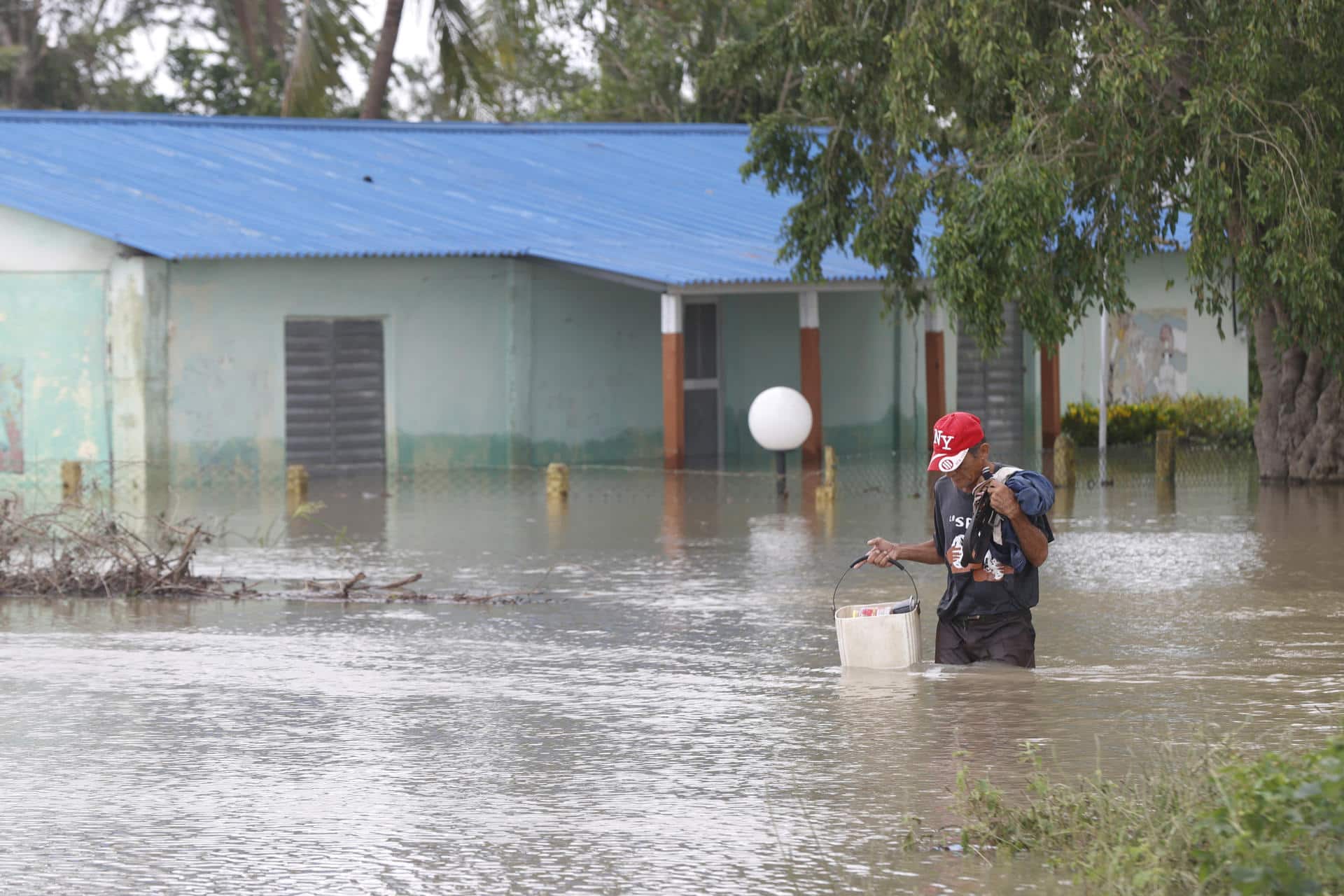 Fotografía del 31 de octubre de 2025 de una persona caminando frente a una casa inundada, en Cauto Cristo (Cuba). EFE/ Ernesto Mastrascusa