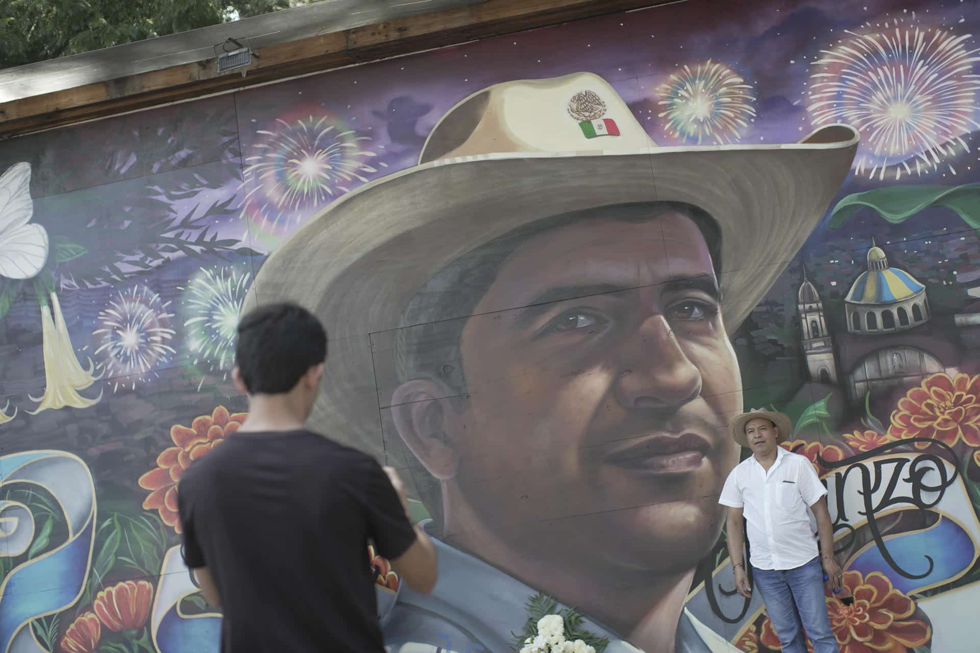Una persona se toma una fotografía el viernes en el mural en memoria del alcalde de la localidad Carlos Manzo, realizado en el Parque Nacional de Uruapan, en el estado de Michoacán (México). EFE/ Iván Villanueva