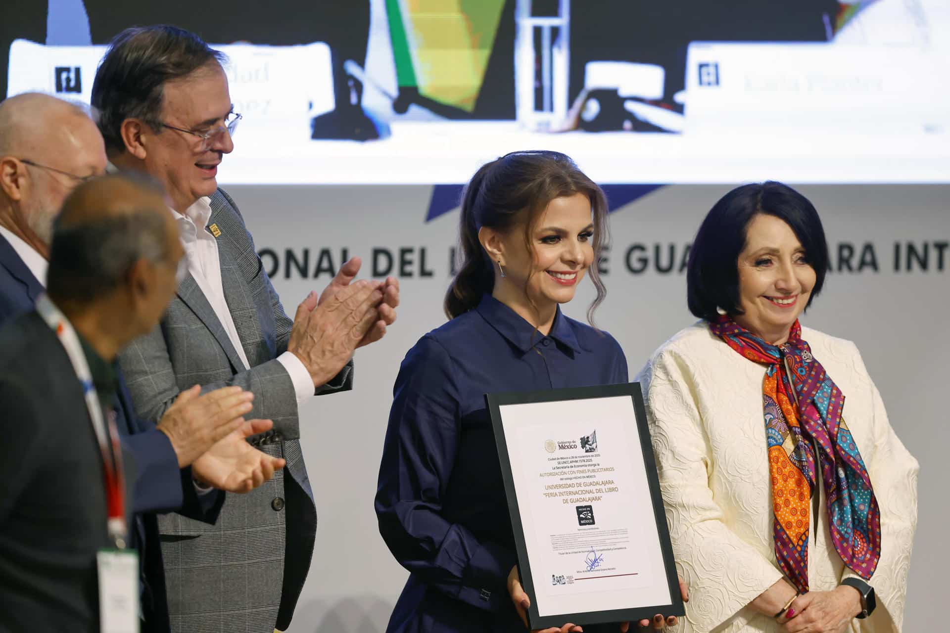 El secretario de economía de México, Marcelo Ebrad (3-i), entrega el reconocimiento 'Hecho en México' a la rectora de la Universidad de Guadalajara, Karla Planter (2-d), durante la 39 edición de la Feria Internacional del Libro de Guadalajara (FIL) este sábado, en Guadalajara, Jalisco (México). EFE/ Francisco Guasco