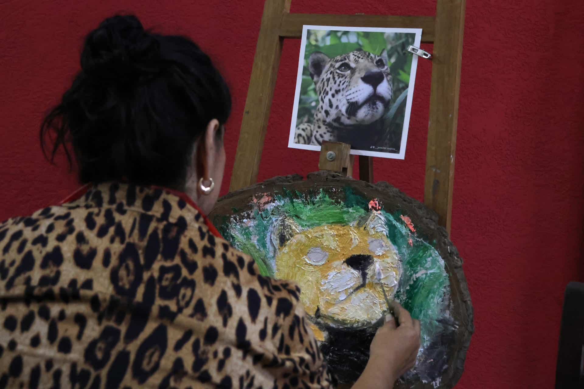 Una mujer pinta una obra en el marco del Día del Jaguar este viernes, en Santa Cruz (Bolivia). EFE/Juan Carlos Torrejón