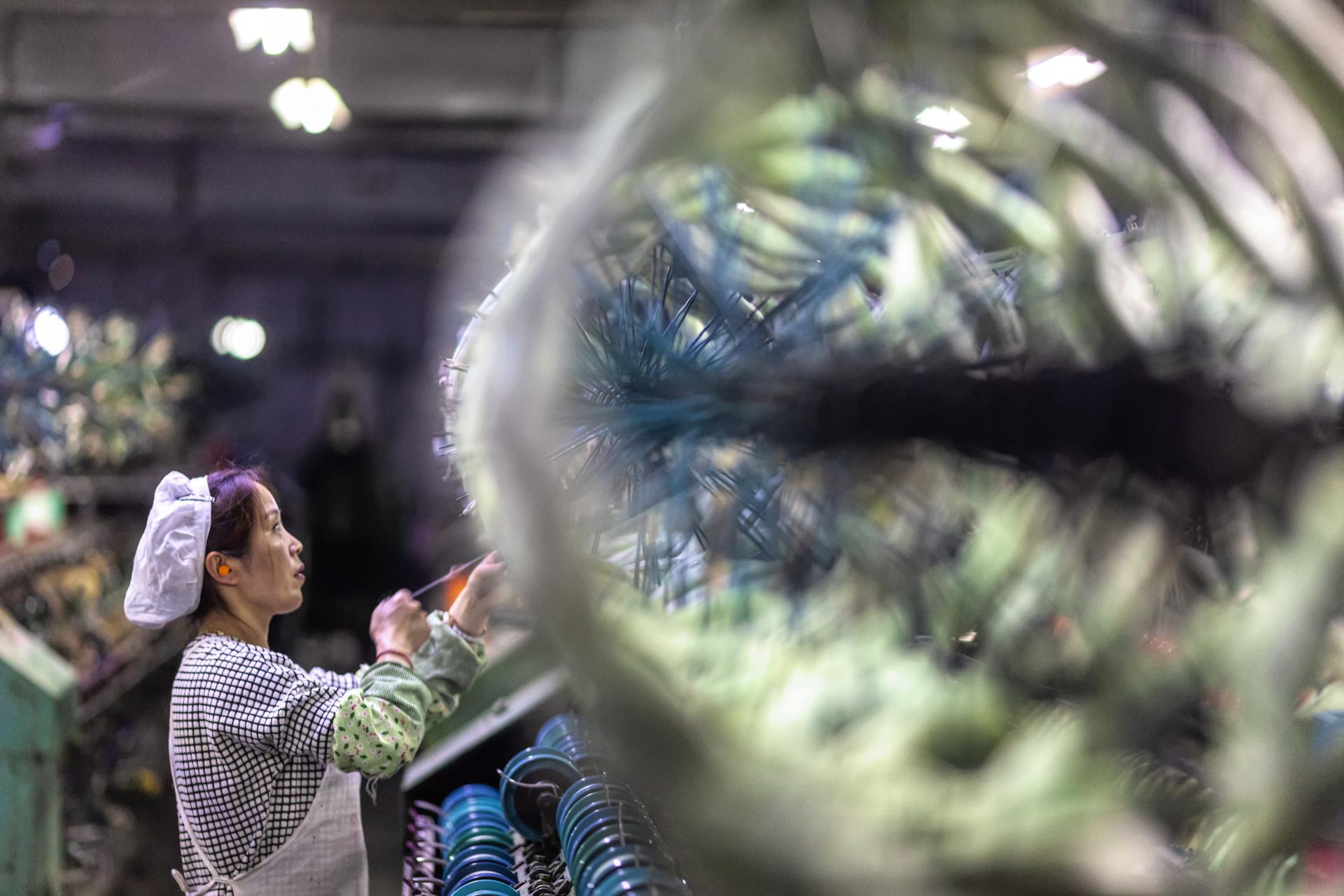 Una mujer trabaja en una fábrica de ropa de seda con maquinaria moderna de producción en Shengze, provincia de Jiangsu, China. EFE/EPA/ALEKSANDAR PLAVEVSKI