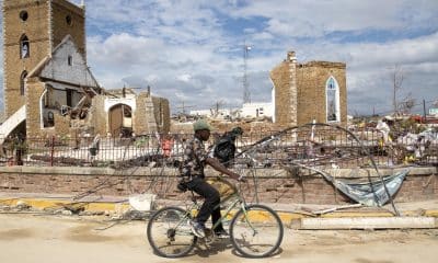 Un hombre recorre en bicicleta frente a escombros de una catedral causados por el huracán Melissa en Black River (Jamaica). Imagen de archivo. EFE/ Orlando Barría