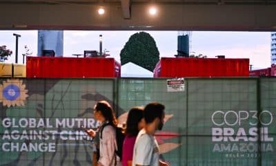 Personas caminan junto a generadores eléctricos que funcionan con diésel a las afueras del Centro de Convenciones Hangar donde se realiza la COP30, este lunes en Belém (Brasil). EFE/ Andre Borges