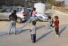 Niños palestinos juegan en la calle de su aldea, bajo la presencia de un vehículo de seguridad israelí el pasado 4 de noviembre, después de que el pequeño espacio para una cancha de fútbol y de baloncesto que tenía el centro comunitario de Umm Al Jeir fuera demolido por colonos israelíes. EFE/ Magda Gibelli