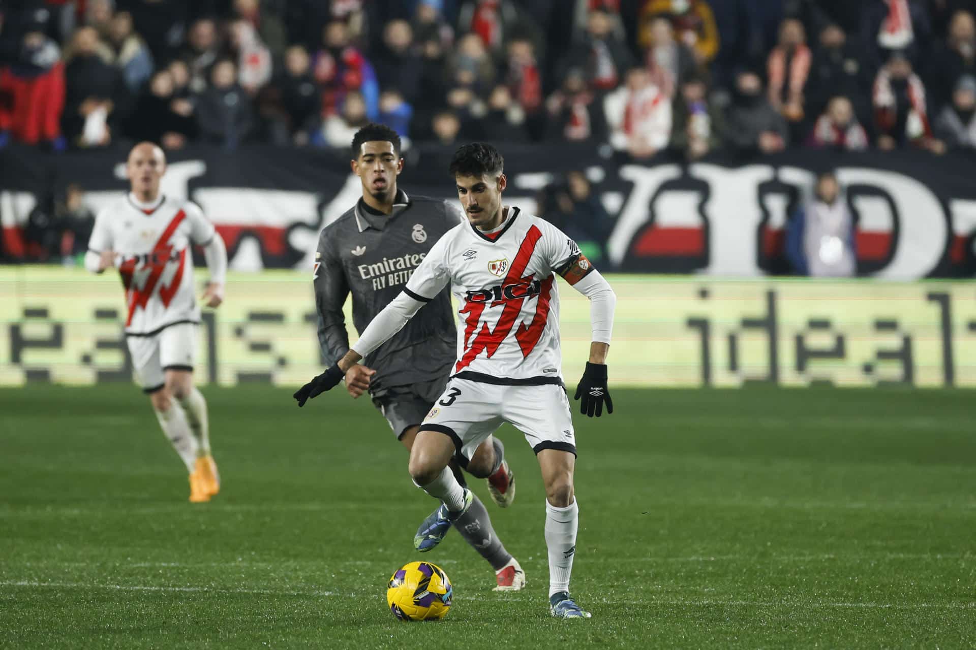 El centrocampista del Rayo Vallecano Óscar Valentín controla el balón ante inglés del Real Madrid Jude Bellingham, durante el encuentro de la pasada temporada disputado en el estadio de Vallecas.EFE / Juanjo Martín.