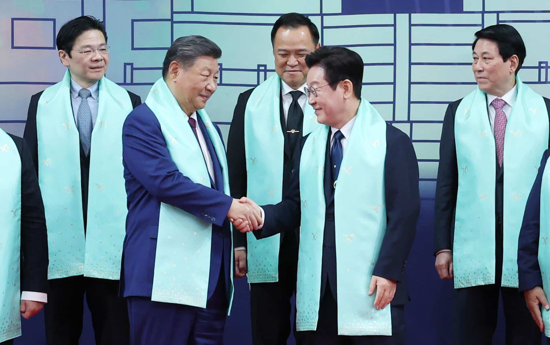 El presidente surcoreano, Lee Jae Myung (D), estrecha la mano con el presidente chino, Xi Jinping, durante la foto del grupo en la cumbre del foro de Cooperación Económica de Asia-Pacífico (APEC), celebrada en la localidad de Gyeongju, (Corea del Sur) EFE/EPA/YONHAP COREA DEL SUR FUERA
