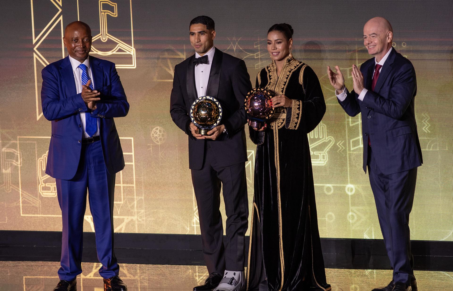 Los marroquíes Achraf Hakimi y Ghizlane Chebbak con los premios que les acreditan como mejor jugador y jugadora de África de 2025, durante la gala celebrada este miércoles y organizada por la Confederación Africana de Fútbol (CAF). EFE/JALAL MORCHIDI