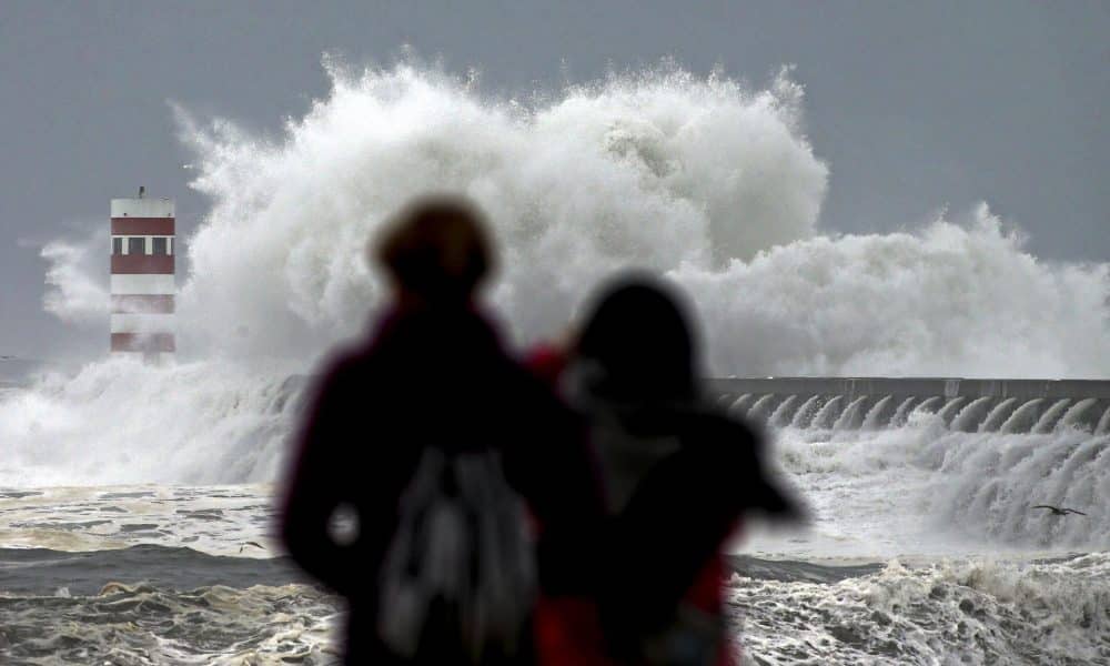 Dos personas observan las olas que chocan contra el faro de Cabedelo en Oporto en una imagen de archivo. EFE/Jose Coelho