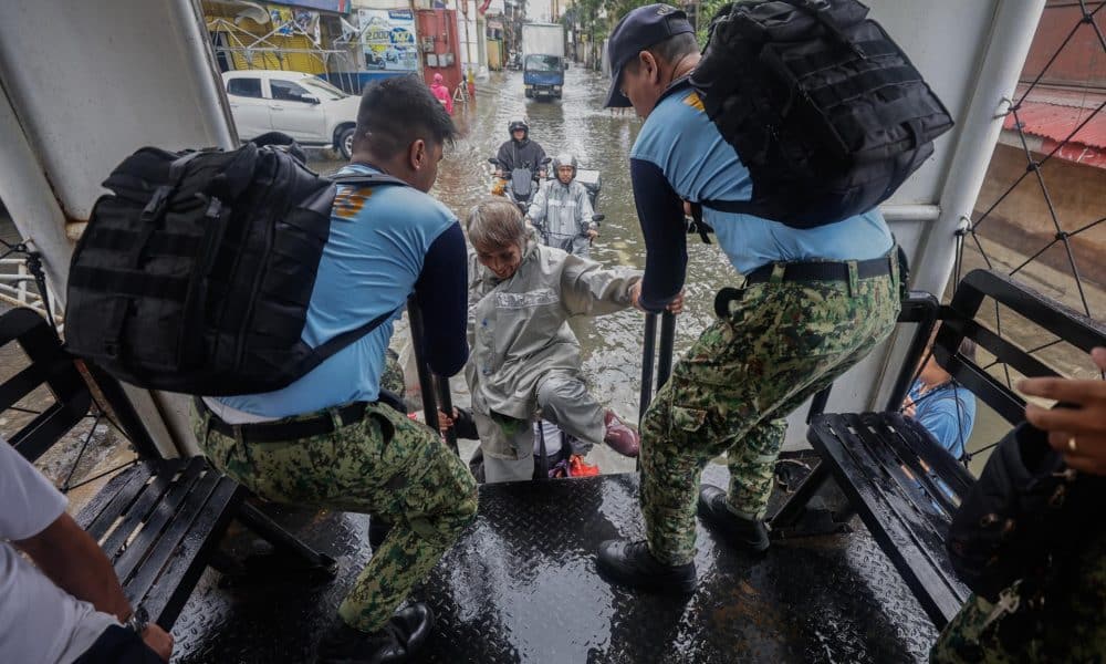 NAVOTAS (Philippines), 10/11/2025.- Philippine police on a truck giving free transportation assist a resident in a district flooded due to high tide and storm surges in coastal areas, caused by typhoon Fung-Wong in Navotas City, Metro Manila, Philippines, 10 November 2025. Typhoon Fung-Wong crossed the Bicol region and northern Luzon region of the country overnight beginning 09 November, causing floods, power outtages and damage to property due strong winds. According to the Philippine Atmospheric, Geophysical, and Astronomical Services Administration (PAGASA), the typhoon is projected to be 135 kilometers west-northwest of La Union province in the northern Philippines moving west-northwest at 20 kilometers per hour with maximum winds of 130 kilometers per hour. (Inundaciones, tormenta, Filipinas) EFE/EPA/ROLEX DELA PENA
