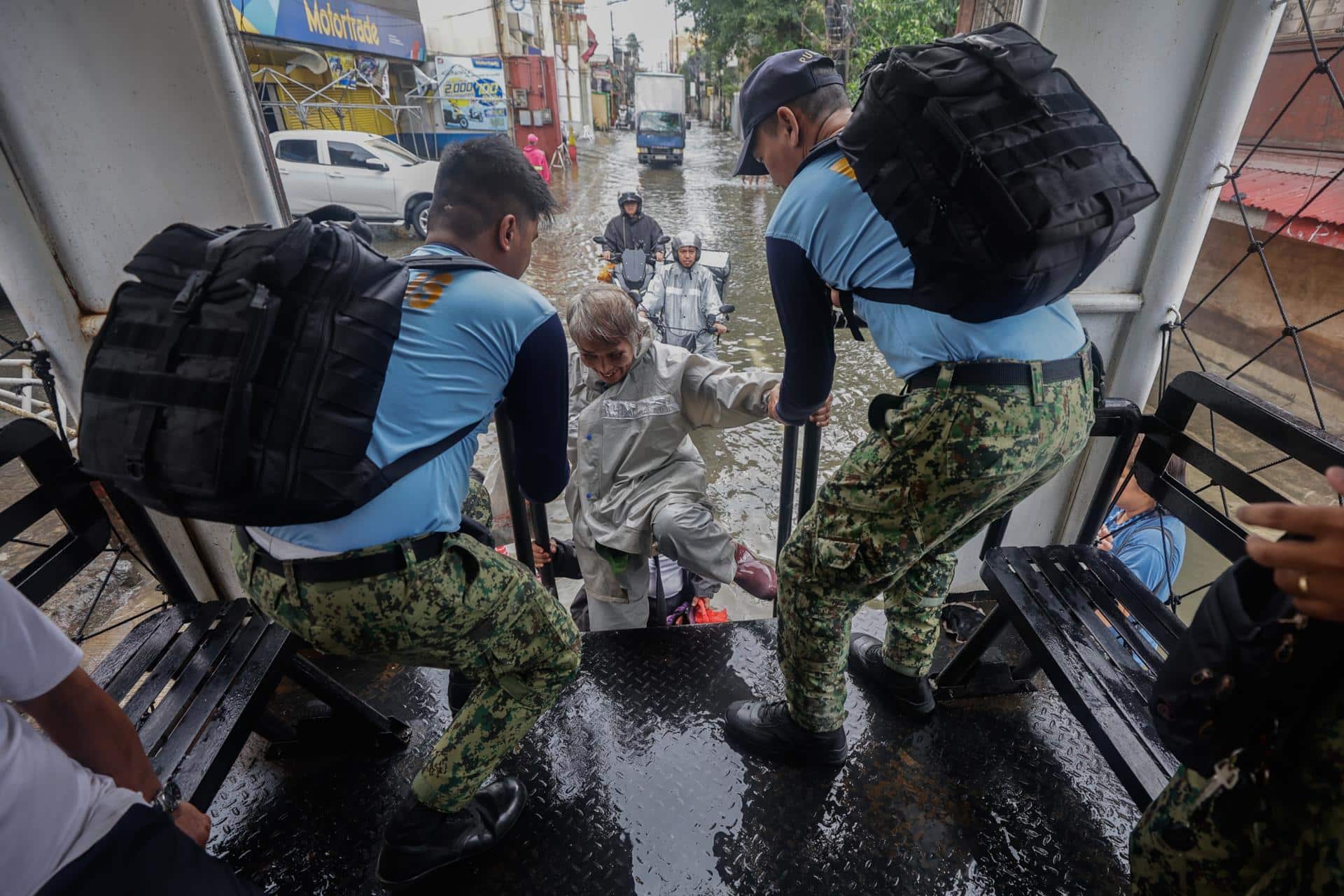 NAVOTAS (Philippines), 10/11/2025.- Philippine police on a truck giving free transportation assist a resident in a district flooded due to high tide and storm surges in coastal areas, caused by typhoon Fung-Wong in Navotas City, Metro Manila, Philippines, 10 November 2025. Typhoon Fung-Wong crossed the Bicol region and northern Luzon region of the country overnight beginning 09 November, causing floods, power outtages and damage to property due strong winds. According to the Philippine Atmospheric, Geophysical, and Astronomical Services Administration (PAGASA), the typhoon is projected to be 135 kilometers west-northwest of La Union province in the northern Philippines moving west-northwest at 20 kilometers per hour with maximum winds of 130 kilometers per hour. (Inundaciones, tormenta, Filipinas) EFE/EPA/ROLEX DELA PENA