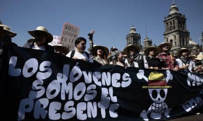 Personas sostienen un cartel durante una protesta este sábado, en inmediaciones del Palacio Nacional en Ciudad de México (México). EFE/ José Méndez