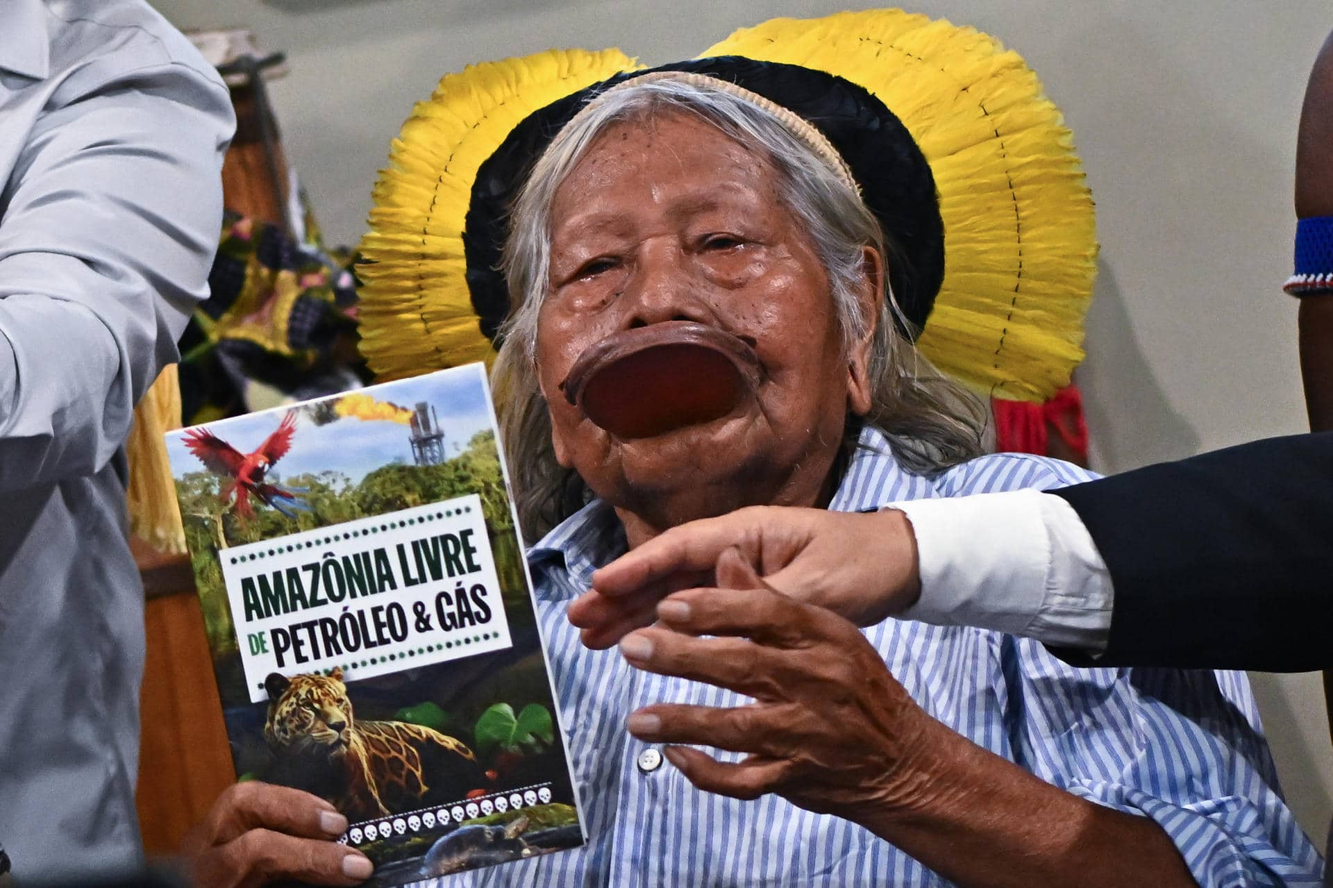 El líder indígena Jefe Raoni Metuktire sostiene un libro este martes, durante un evento en el Centro de Convenciones Hangar, durante la COP30 en Belém (Brasil). EFE/ Andre Borges