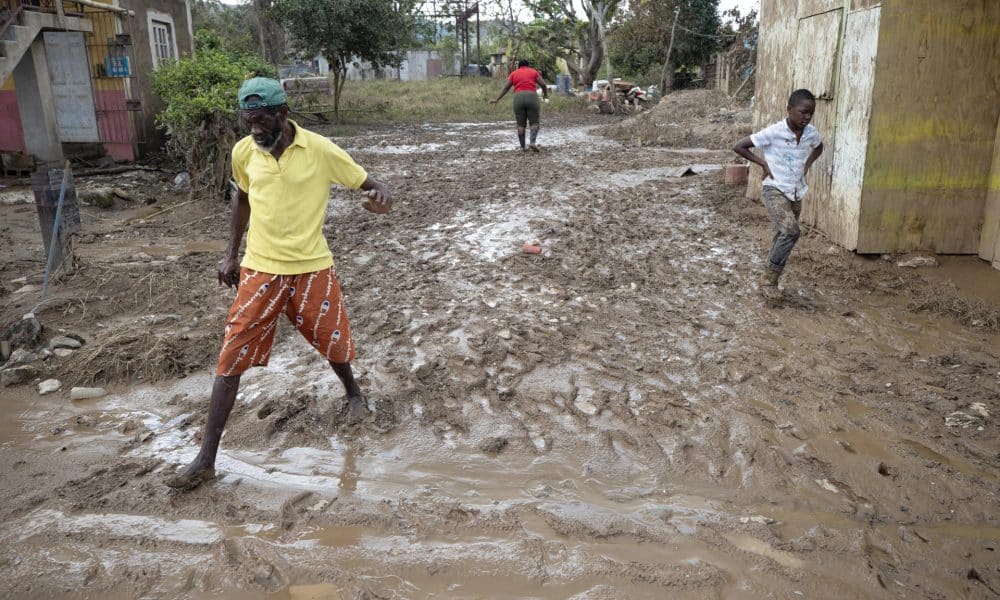 Personas caminan por una calle afectada por el paso del huracán Melissa, este domingo en Cave Valley (Jamaica). EFE/ Orlando Barría