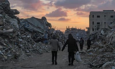 Palestinos caminan cerca de edificios destruidos en un día lluvioso en el este de la ciudad de Gaza, Franja de Gaza, el 16 de noviembre de 2025. EFE/EPA/MOHAMMED SABER