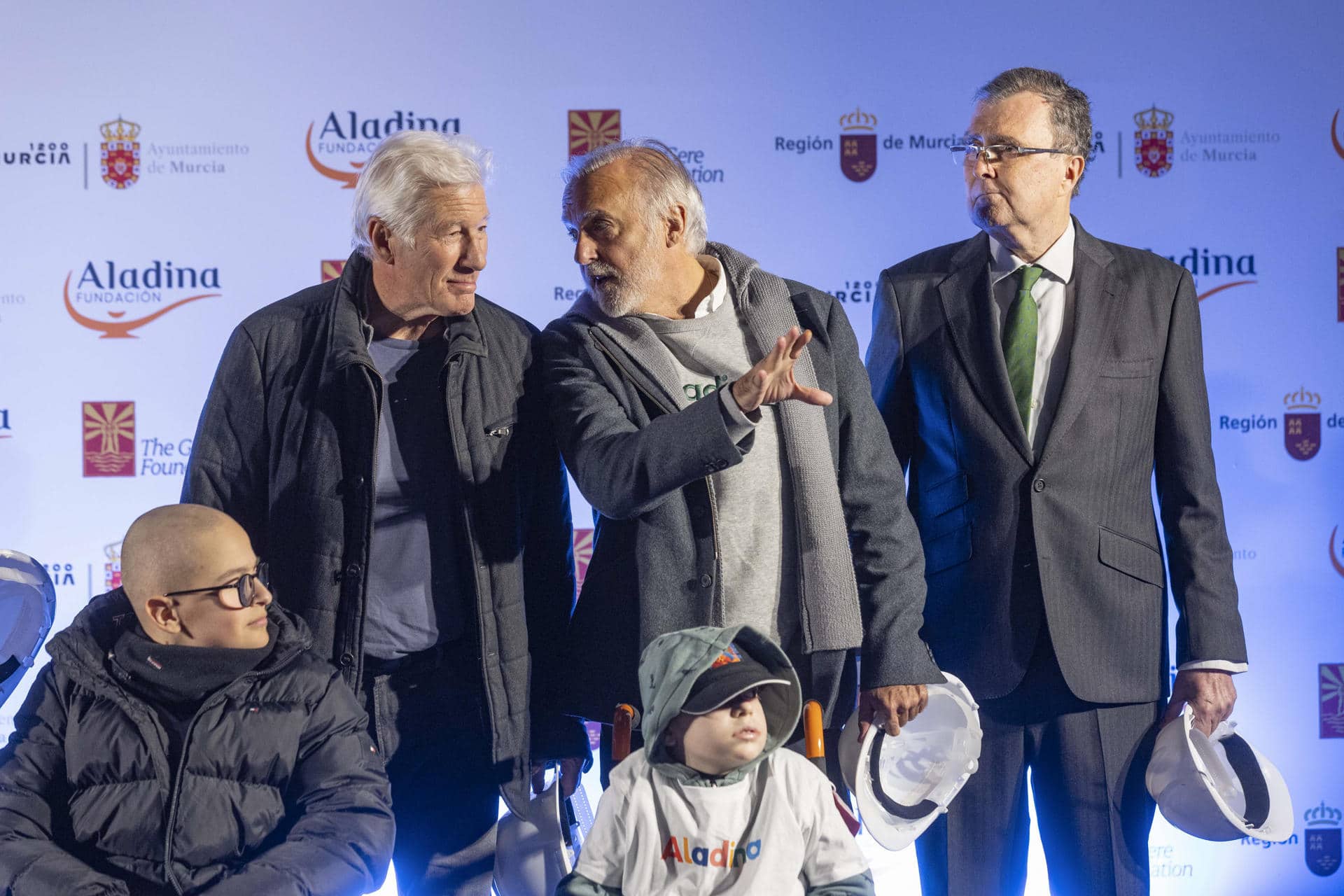 - El actor Richard Gere (2d), el fundador de la Fundación Aladina, Francisco Arango (c), y el alcalde de Murcia José Ballesta (dcha), asisten al acto de colocación de la primera piedra de las obras del mayor gimnasio pediátrico hospitalario del país, en el hospital Virgen de la Arrixaca de Murcia. EFE/Marcial Guillén