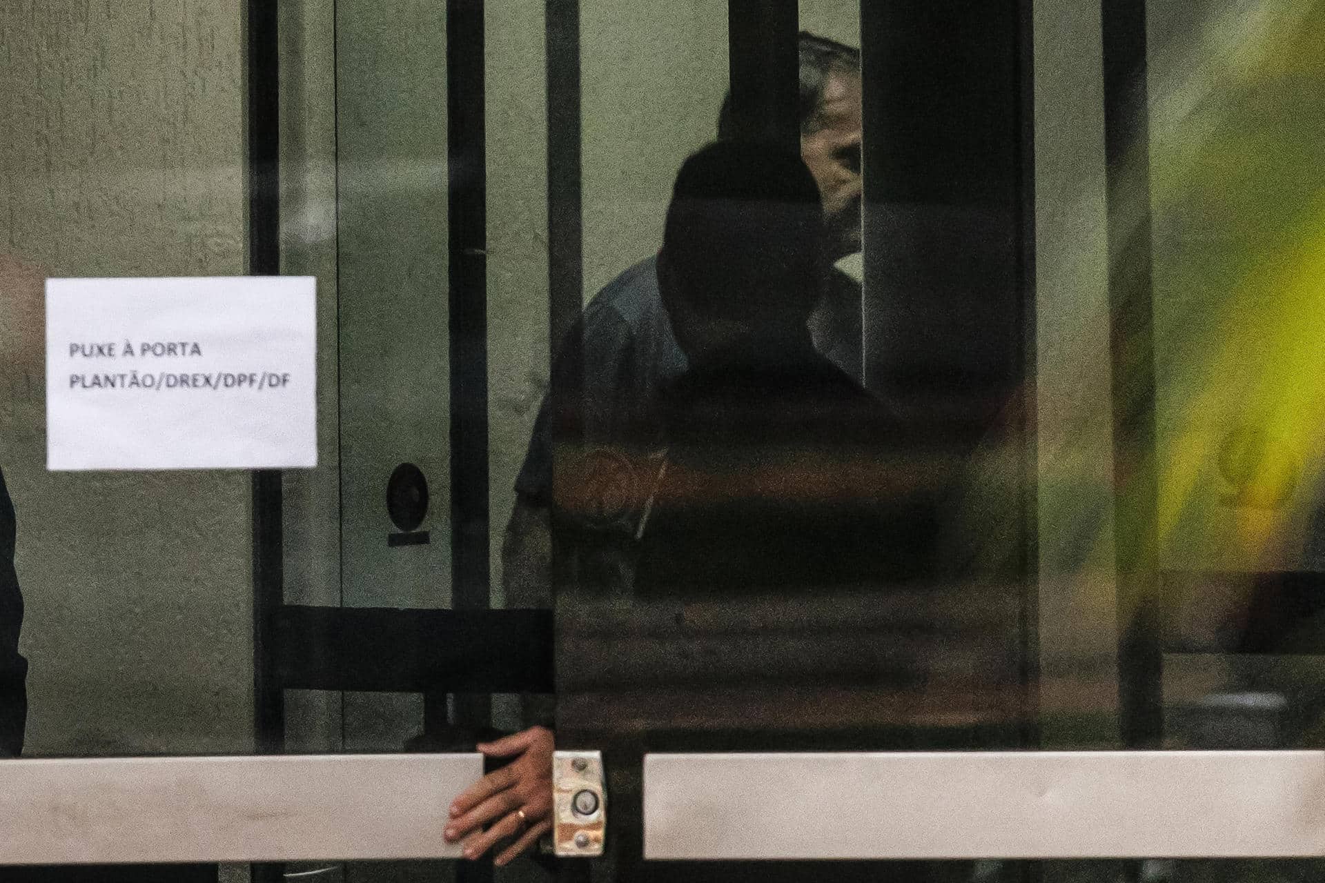 Fotografía que muestra al expresidente de Brasil Jair Bolsonaro detrás de una puerta de vidrio este domingo, en la Superintendencia de la Policía Federal en Brasilia (Brasil). EFE/ Isaac Fontana