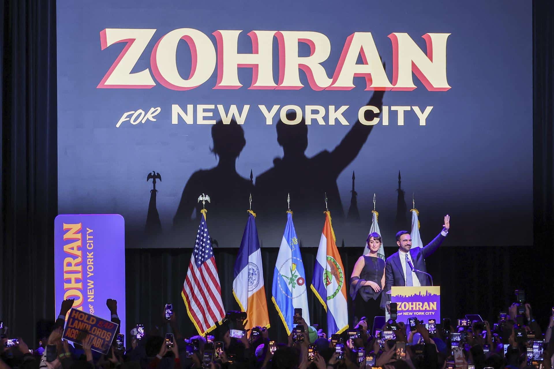 El alcalde electo de la ciudad de Nueva York, Zohran Mamdani (i), y su esposa, Rama Duwaji (d), saludan a la multitud durante una fiesta celebrada por el candidato demócrata en Brooklyn, Nueva York. EFE/ Sarah Yenesel