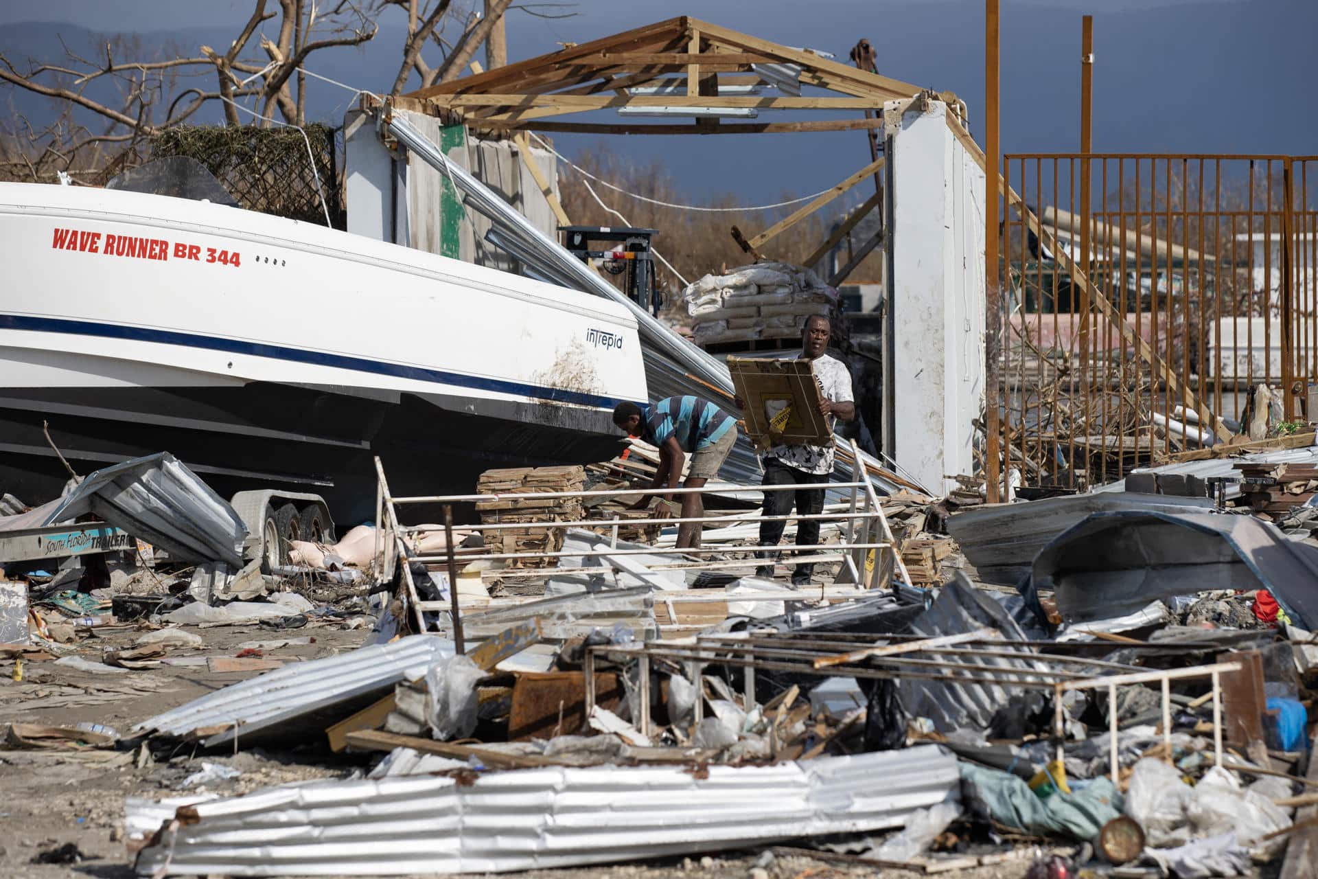 Un hombre saca productos de una tienda este viernes, en Black River (Jamaica). EFE/ Orlando Barría