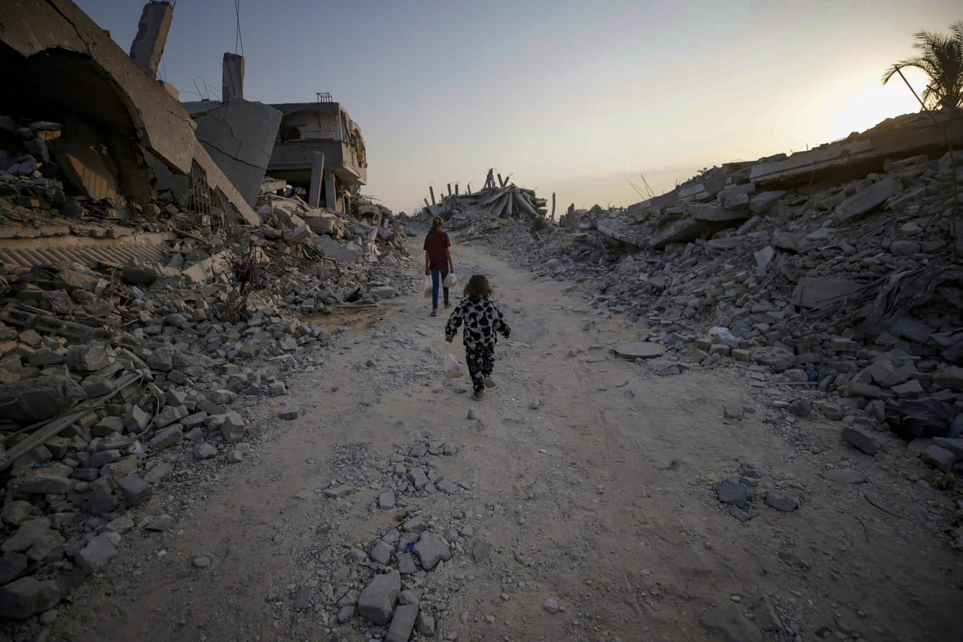 Dos niñas palestinas entre edificios destruidos en Gaza el 4 de noviembre de 2025. EFE/EPA/MOHAMMED SABER