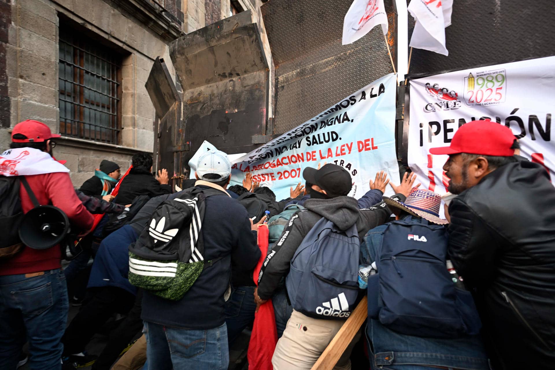 Integrantes de la Coordinadora Nacional de Trabajadores de la Educación (CNTE), se manifiestan este jueves afuera del Palacio Nacional de la Ciudad de México (México). EFE/José Méndez