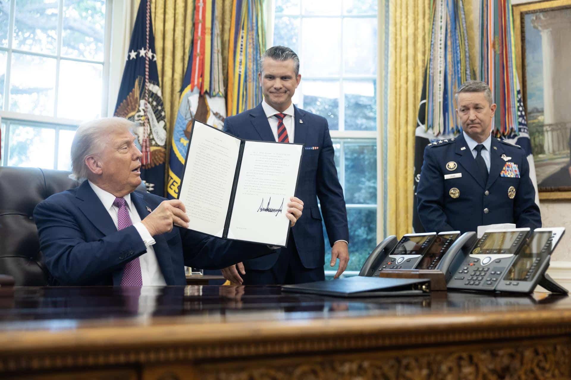 Fotografía de archivo, tomada el pasado 5 de septiembre, en la que se captó al presidente de EE.UU., Donald Trump (i), tras la firma de varias órdenes ejecutivas, junto a su secretario de Guerra, Pete Hegseth (c), y al jefe del Estado Mayor Conjunto de las Fuerzas Armadas estadounidenses, Dan Caine (d), en el Despacho Oval de la Casa Blanca, en Washington DC (EE.UU.). EFE/Francis Chung/Pool