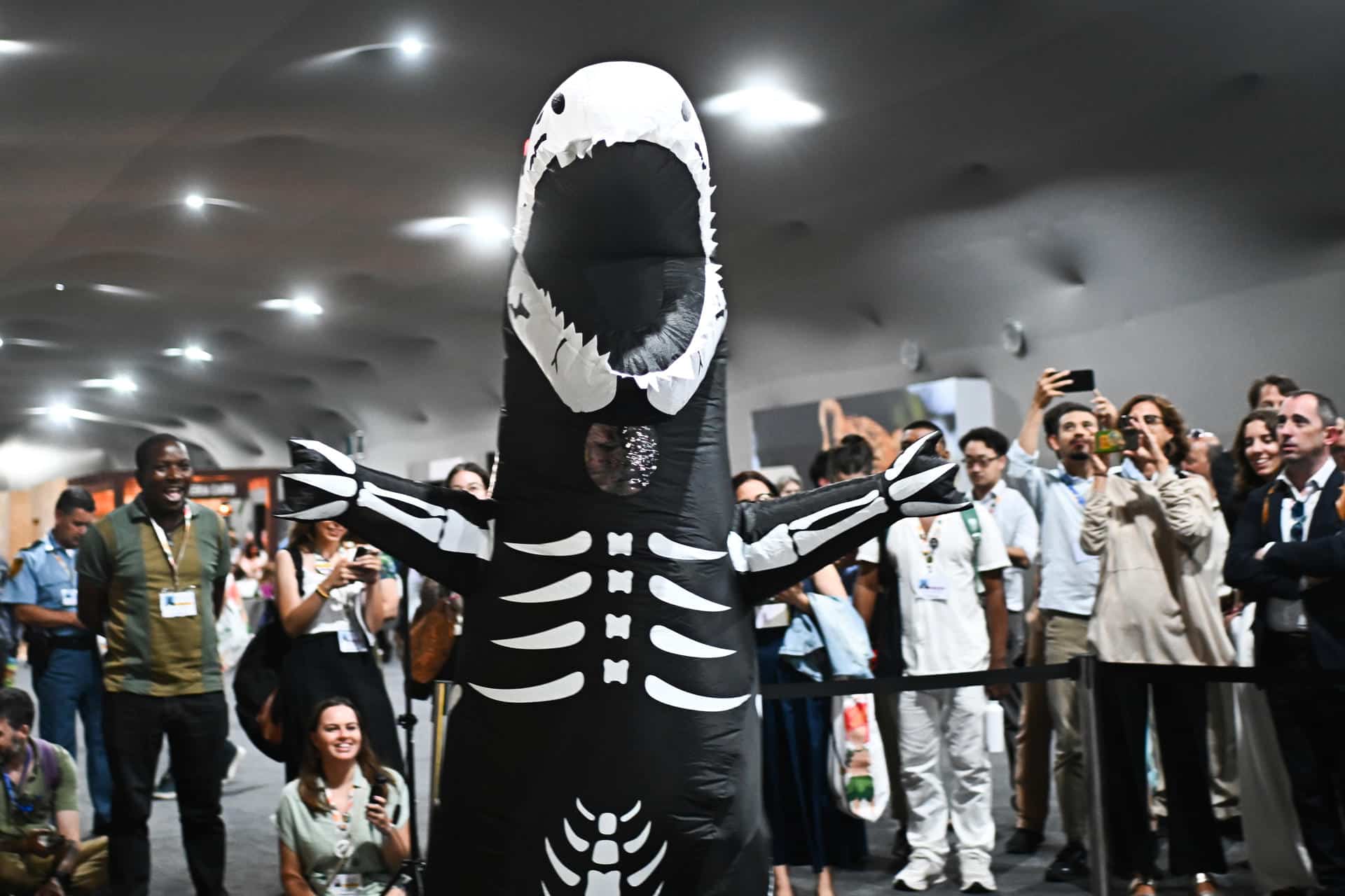 Una persona disfrazada anima durante la tradicional ceremonia de entrega del premio 'Fósil del Día' este viernes, en el Centro de Convenciones Hangar en Belém (Brasil). EFE/Andre Borges