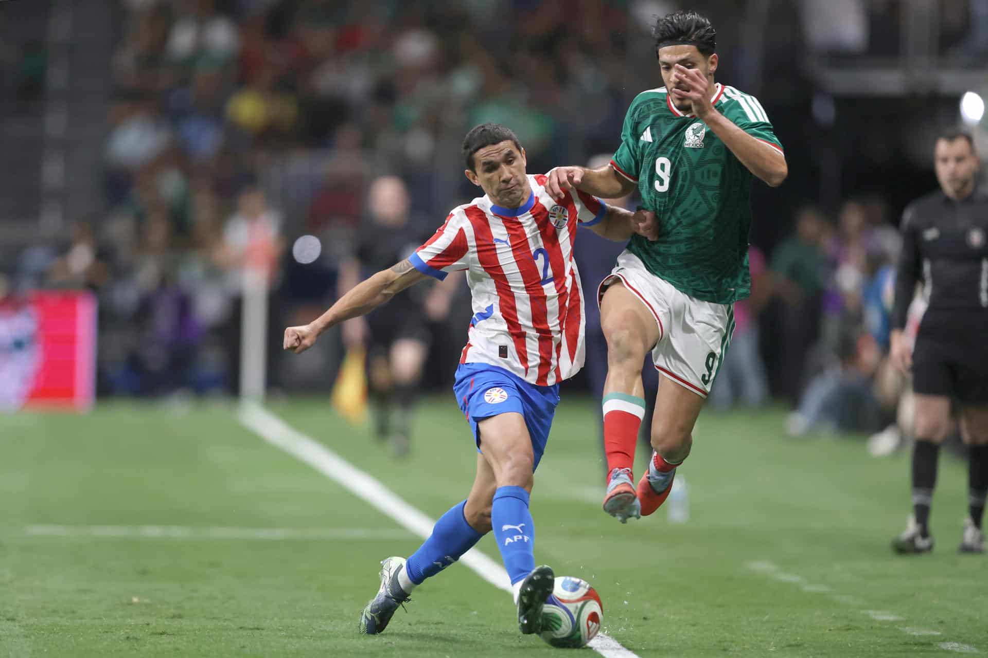 Raúl Jiménez (d), de México, disputa un balón con Gustavo Velázquez, de Paraguay, en un partido amistoso entre México y Paraguay en el Alamodome en San Antonio (Estados Unidos). EFE/Carlos Ramírez