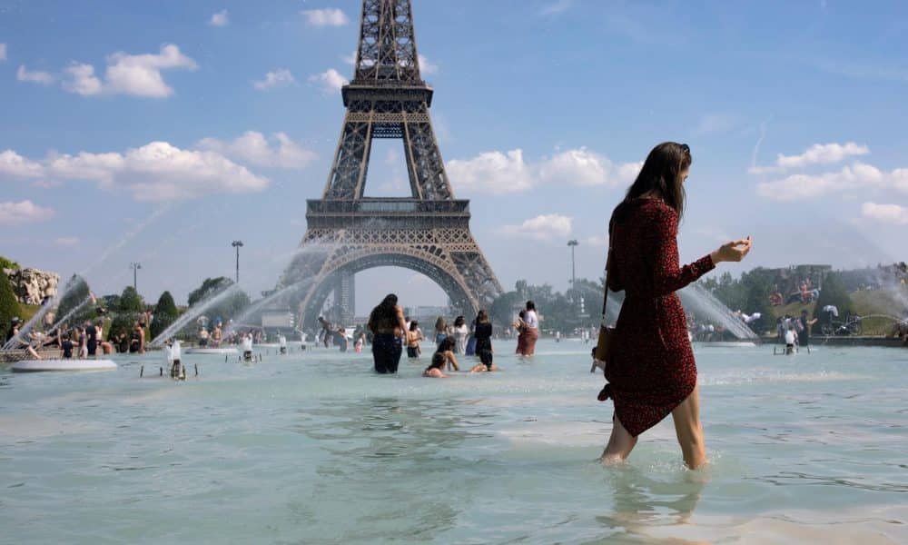 En la imagen de archivo, una mujer se refresca con el agua de la fuente de la Plaza del Trocadero, frente a la Torre Eiffel. EFE/Ian Langsdon