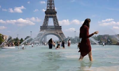 En la imagen de archivo, una mujer se refresca con el agua de la fuente de la Plaza del Trocadero, frente a la Torre Eiffel. EFE/Ian Langsdon