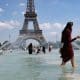 En la imagen de archivo, una mujer se refresca con el agua de la fuente de la Plaza del Trocadero, frente a la Torre Eiffel. EFE/Ian Langsdon