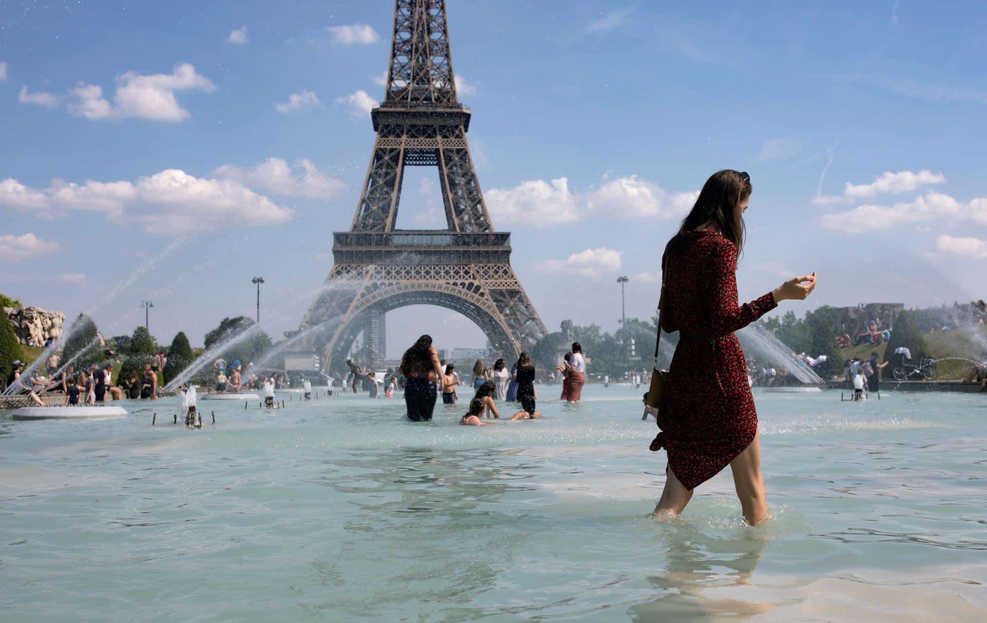 En la imagen de archivo, una mujer se refresca con el agua de la fuente de la Plaza del Trocadero, frente a la Torre Eiffel. EFE/Ian Langsdon