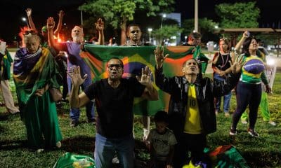 Simpatizantes del expresidente de Brasil, Jair Bolsonaro, rezan frente a la sede de la Policía Federal donde el exmandatario permanece detenido este sábado, en Brasilia (Brasil).. EFE/ Isaac Fontana