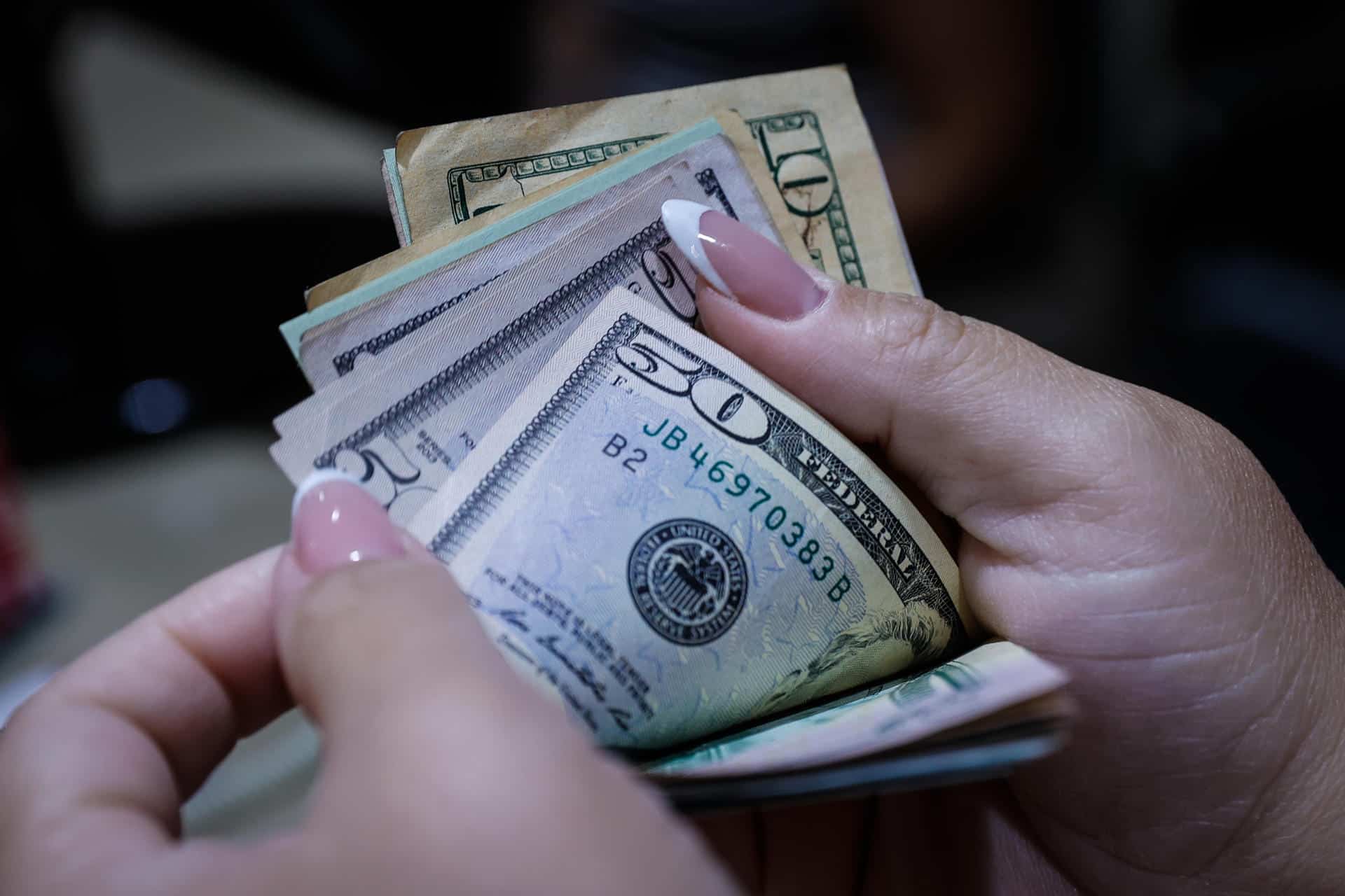 Fotografía de archivo donde aparece una persona muestra dólares estadounidenses en una oficina de cambio de moneda. EFE/ André Coelho