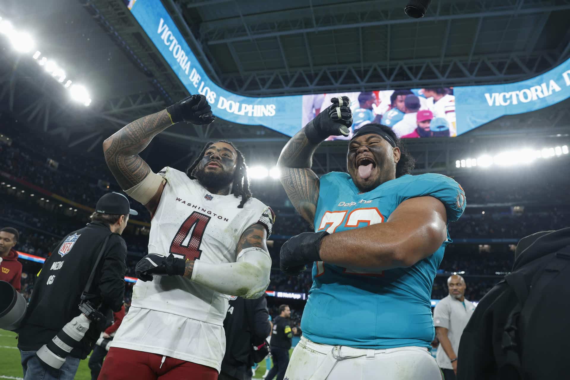 El jugador del Miami Dolphins Jonah Savaiinaea y el jugador del Washington Commanders Frankie Luvu, tras el partido de liga regular de la Liga de Fútbol Americano (NFL), que disputaron los equipos Miami Dolphins y Washington Commanders en el Estadio Santiago Bernabéu. EFE/JuanJo Martín