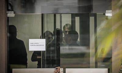 Fotografía que muestra al expresidente de Brasil Jair Bolsonaro (2-d) detrás de una puerta de vidrio este domingo, en la Superintendencia de la Policía Federal en Brasilia (Brasil). EFE/ Isaac Fontana