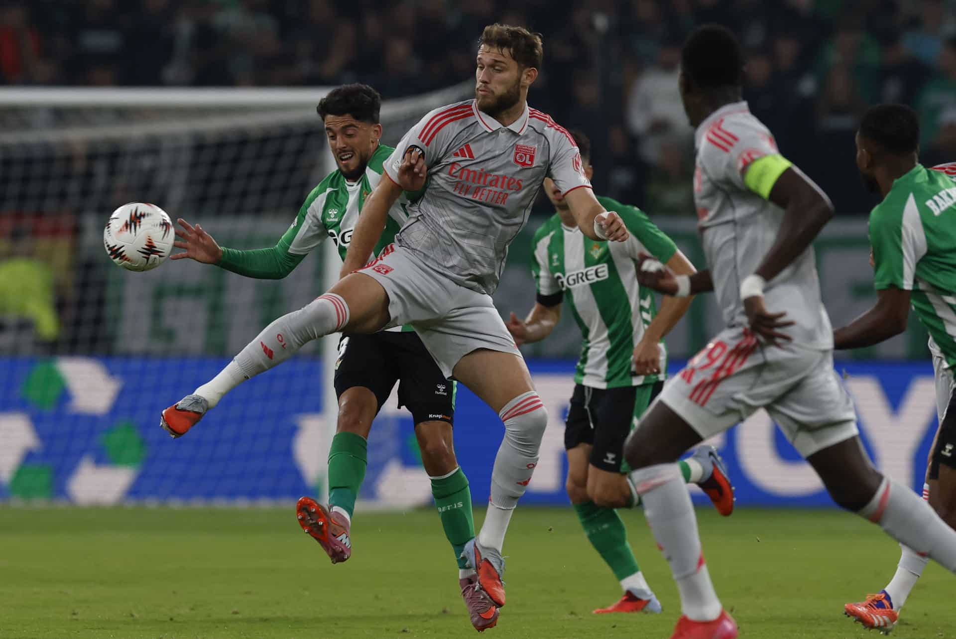 Pablo Fornals (i) pugna por el balón con el centrocampista del Lyon midfielder Tanner Tessmann (C), durante el partido de la Liga Europa que disputó con el Betis este jueves. EFE/Julio Munoz