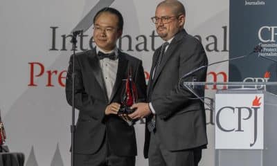El fotógrafo Juan Arredondo (d) entrega a Dong Yifu, hijo del periodista chino preso Dong Yuyu, un reconocimiento durante los premios del Comité para la Protección de los Periodistas (CPJ) este jueves, en Nueva York (Estados Unidos). EFE/ Ángel Colmenares