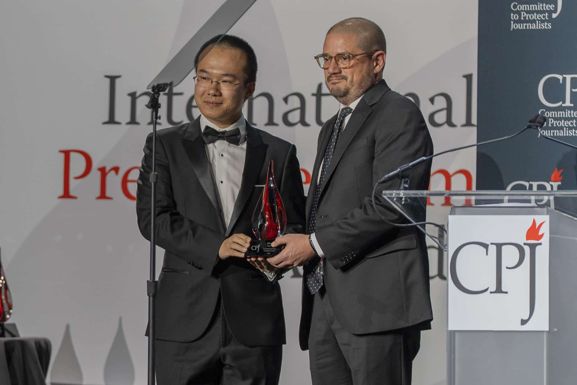 El fotógrafo Juan Arredondo (d) entrega a Dong Yifu, hijo del periodista chino preso Dong Yuyu, un reconocimiento durante los premios del Comité para la Protección de los Periodistas (CPJ) este jueves, en Nueva York (Estados Unidos). EFE/ Ángel Colmenares