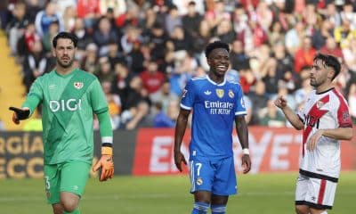 El delantero del Real Madrid Vinicius Jr (c) sonríe junto a Augusto Batalla (i) y Unai López (d), del Rayo Vallecano, durante el partido de la jornada 12 de LaLiga EA Sports que Rayo Vallecano y Real Madrid disputan este domingo en el Estadio de Vallecas, en la capital española. EFE/Mariscal