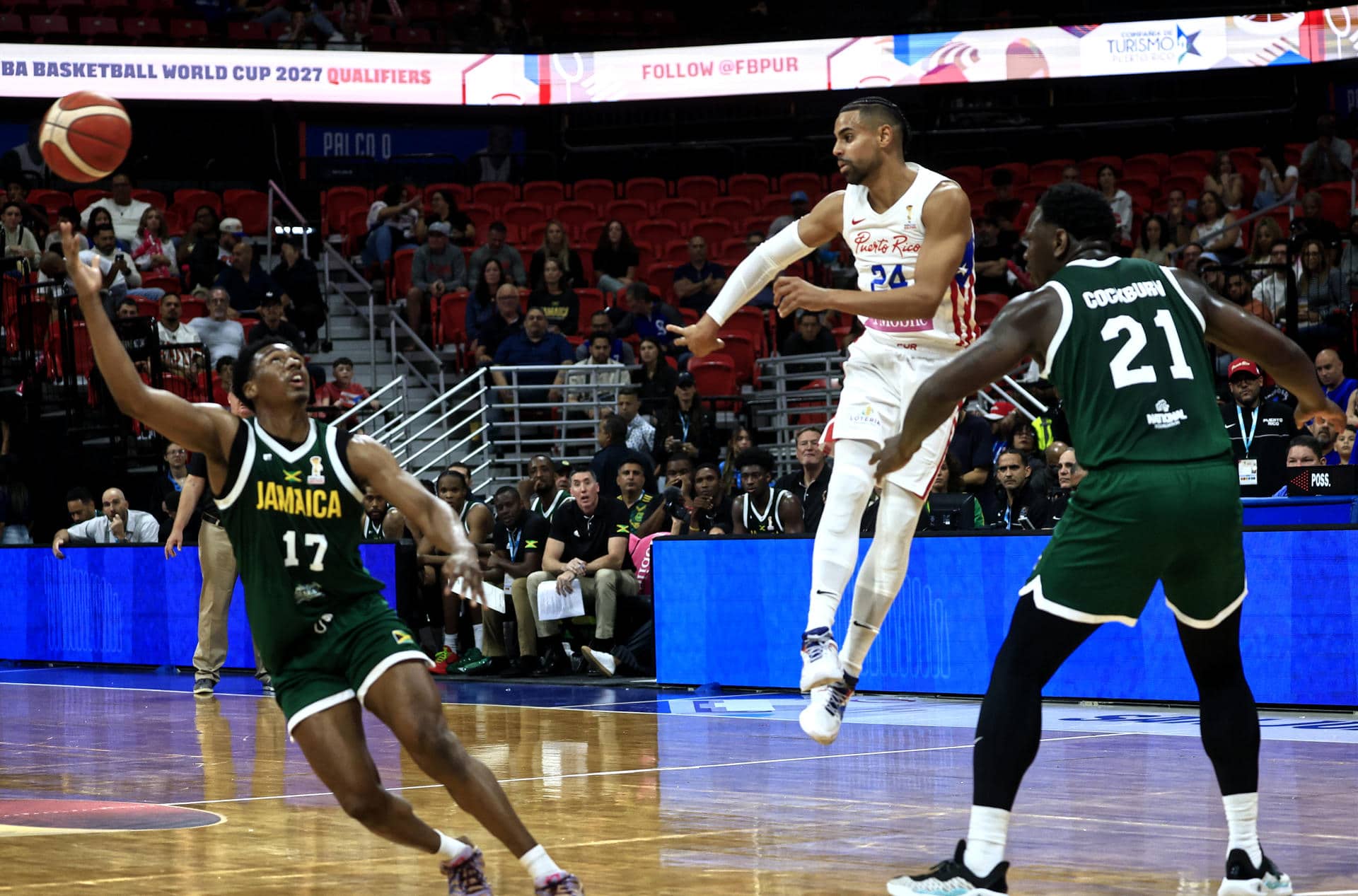 Gian Clavell (c), de Puerto Rico, disputa un balón con Chase Audige (i) y Kofi Cockburn, de  Jamaica, durante un partido de la primera ronda del grupo B de la clasificación para la Copa Mundial de Baloncesto 2027 entre Puerto Rico y Jamaica en el Coliseo Roberto Clemente, en San Juan (Puerto Rico). EFE/Thais Llorca