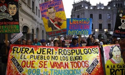 Personas sostienen carteles en una manifestación contra el gobierno este viernes, en Lima (Perú). EFE/ Paolo Aguilar
