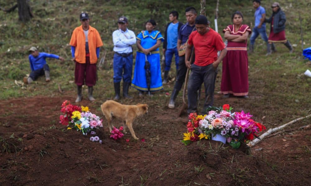 Personas oran acompañados por un perro este viernes, en el cementerio del poblado de Cascabel, distrito de Mironó, en la comarca Ngäbe Buglé (Panamá). EFE/ Bienvenido Velasco