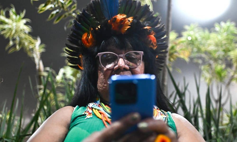 Una mujer indígena fue captada este miércoles, 12 de noviembre, al usar su teléfono móvil, en el Centro de Convenciones Hangar donde se realiza la COP30, en Belém (Brasil). EFE/Andre Borges