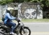 Fotografía del 5 de noviembre de 2025 que muestra a una persona transitando en motocicleta frente a un muro de una casa destruida con la imagen de Omaira, en Armero (Colombia). EFE/ Mauricio Dueñas Castañeda
